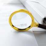 audit concept – magnifying glass and business documents