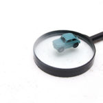 small toy car on a magnifier white background copy space, search