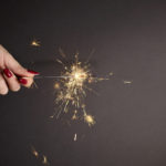 Sparkler in woman hand with red nail polish